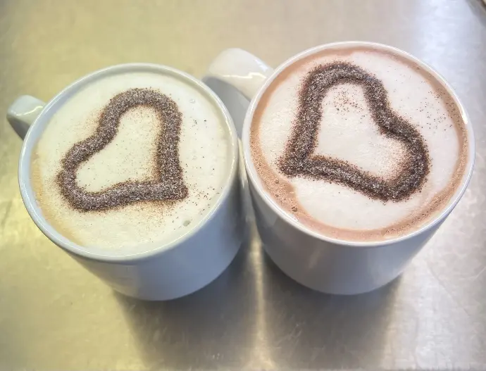 Feinkost Kaisen - Ein Cappuccino und eine heiße Schokolade mit einem Schokoladenherz auf dem Milchschaum